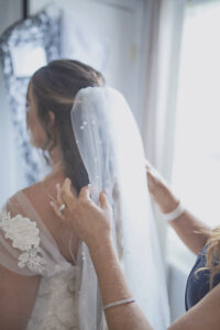 Bride wearing a veil with scattered pearls.