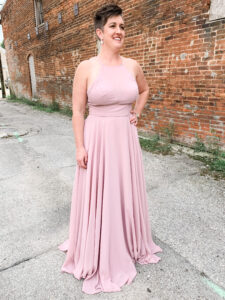 woman standing outside wearing a blush pink bridal gown