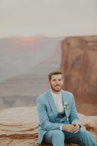 Groom in a tuxedo with mountain views.