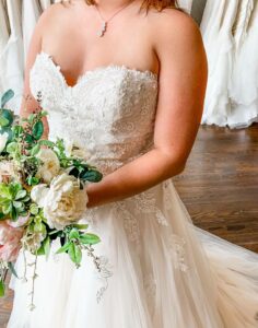 strapless lace wedding dress and a bouquet of flowers