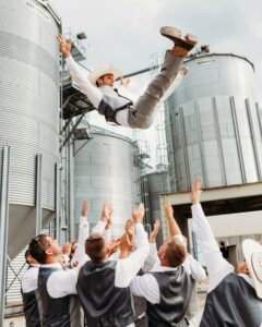 groom being lifted in the air from his group of groomsmen